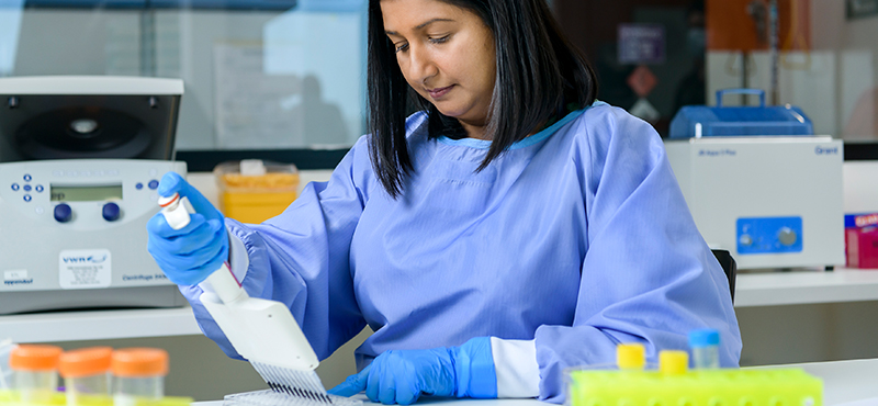A researcher collecting samples with a a pipette