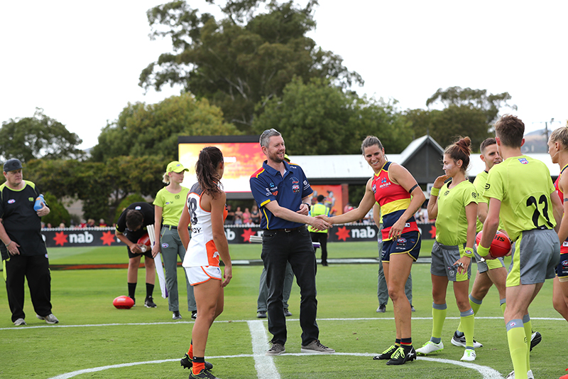 UniSA Vice Chancellor and President Professor David Lloyd, shaking hands with Crows AFLW Co-captain and UniSA Education student Chelsea Randall at the AFLW Crows vs GIANTS clash on 10 May. Photo by AFC Photography