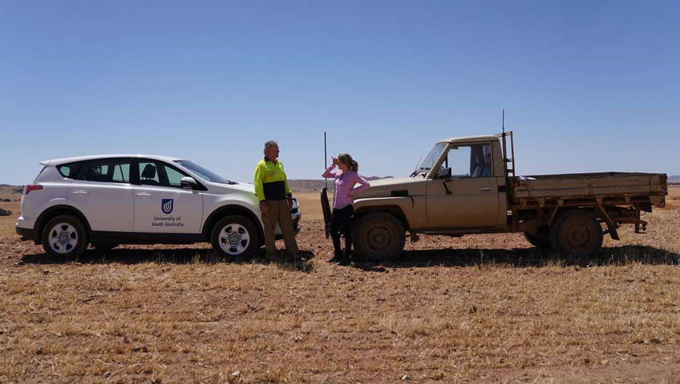 Dr Gunn talking with a farmer on the land