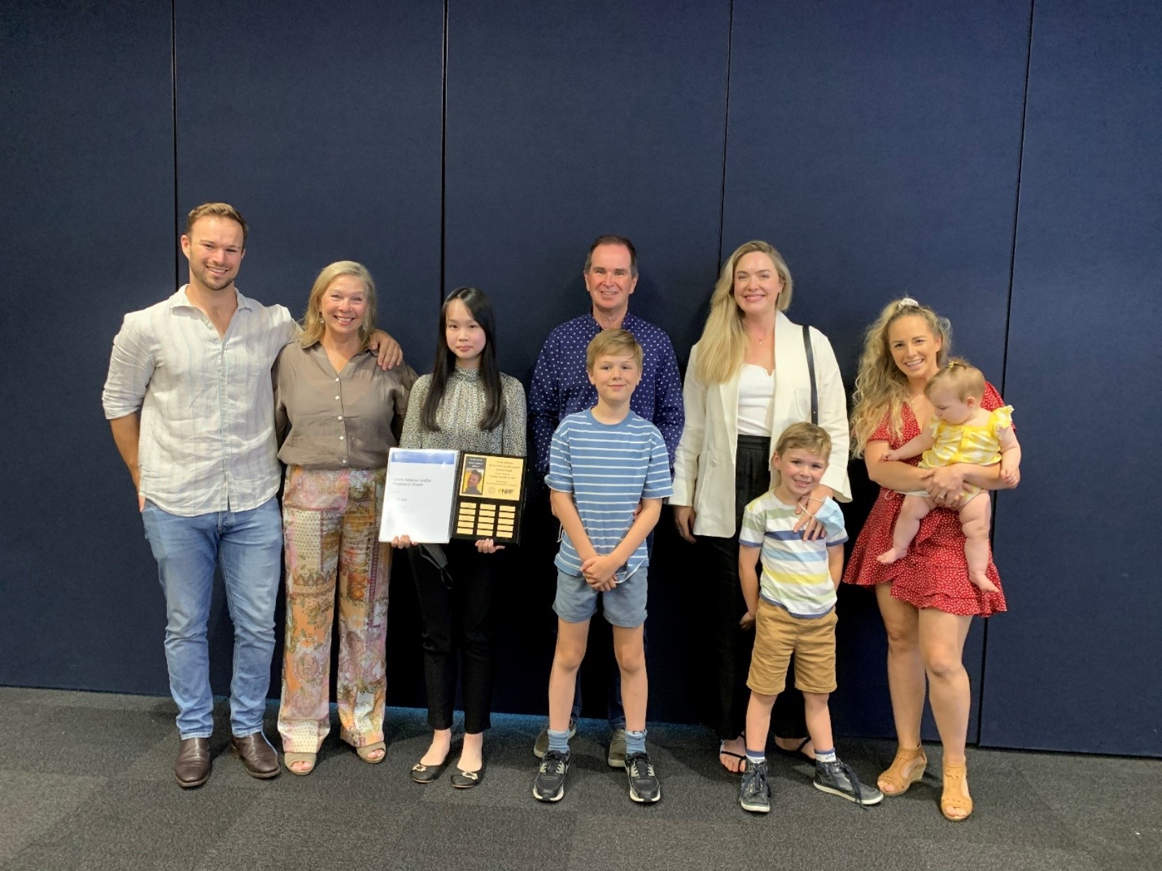 Chris Adams’s brother, mother, father, sisters-in-law, niece and nephews at the 2021 Chris Adams UniSA Research Grant presentation with researcher Erica Yeo (second to left).
