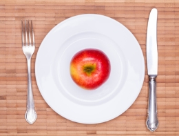 Apple on a dinner plate with knife and fork