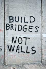 Wall graffitied with the words BUILD BRIDGES NOT WALLS.