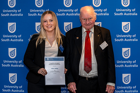 Nikia receiving the Yangadlitya Aboriginal Postgraduate Scholarship from Dr Uncle Lewis O'Brien AO FUniSA