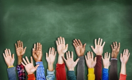 hands in front of blackboard in classroom