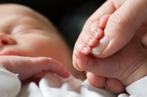 Newborn baby and hand