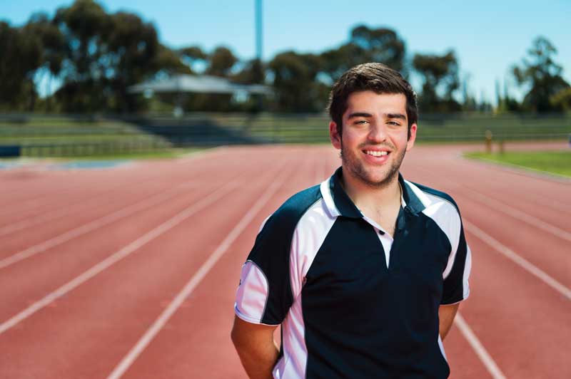 Student standing on an athletics running track