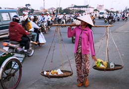 Street scene in Hue Vitenam showing cyclists and people on foot carrying goods