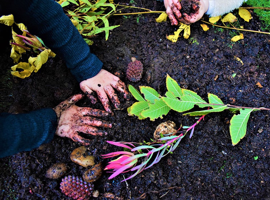 nature play image of children playing outside with nature