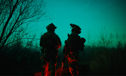 Two military personnel standing next to each other at night - Photo by Aleksey Kashmar on Unsplash