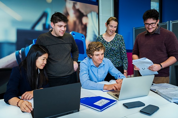 Group of students looking at a laptop