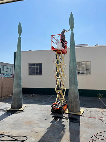 Staff at The Big New in Los Angeles painting a bronze work by Sterling Ruby