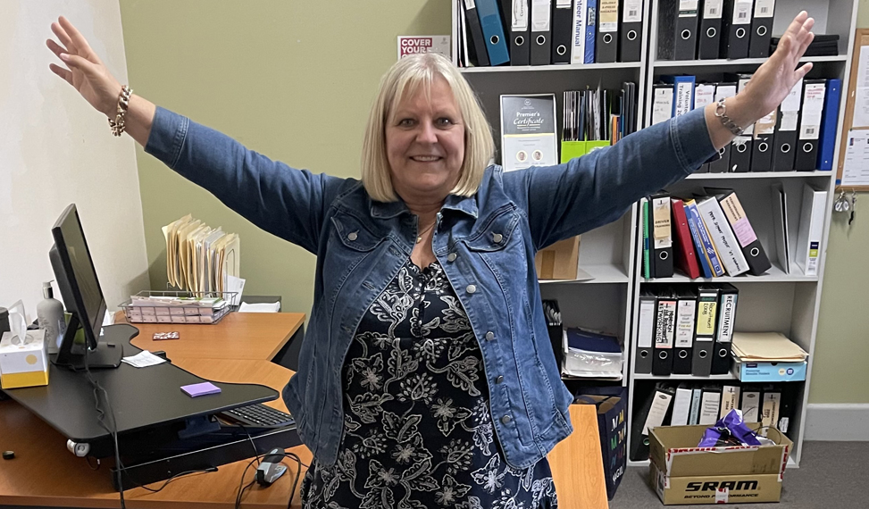 Helen McLean in her office performing a star jump