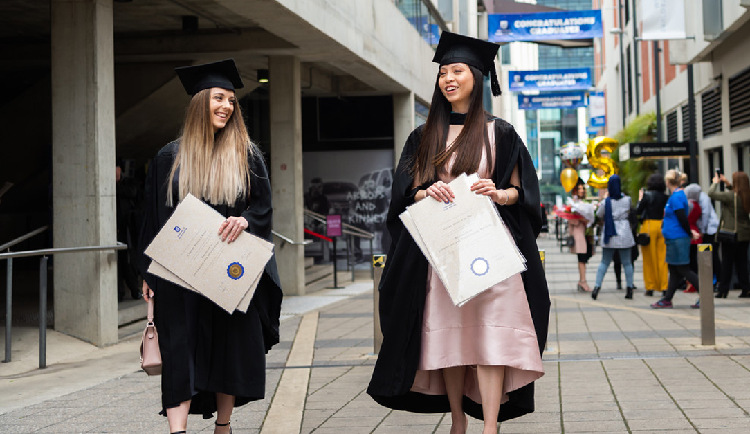 Image of students with parchments at UniSA graduation ceremony. Text: Read UniSA's new Academic Enterprise Plan (2021 - 2025)