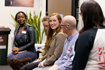 People sitting and talking as they participate in a networking event