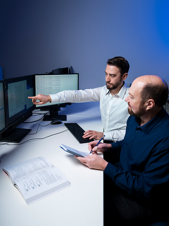 Two researchers working in front of a computer screen
