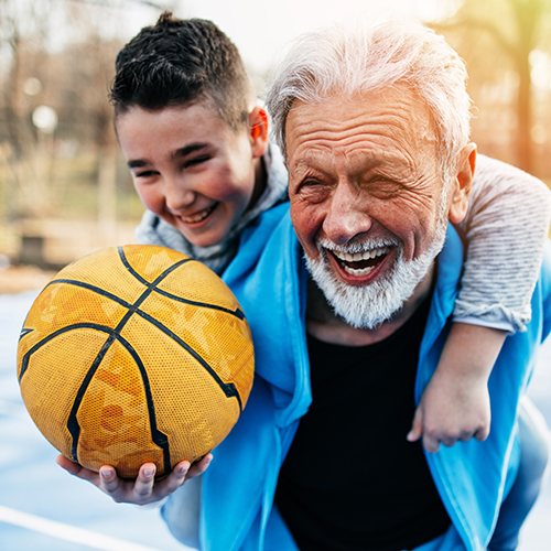 child and grandpa play basketball