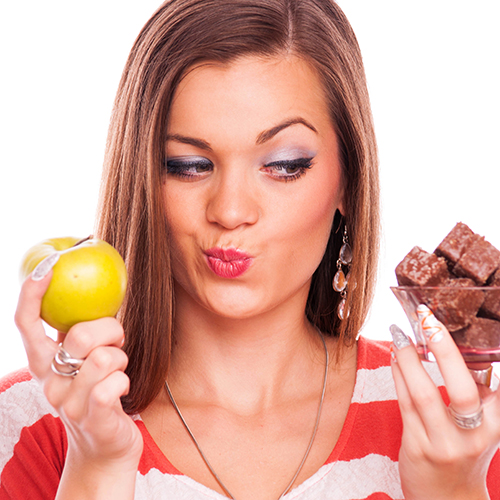 Woman considering apple or chocolate