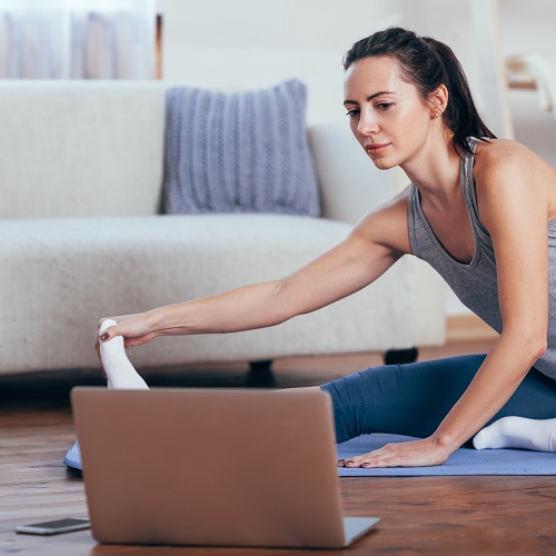Woman doing yoga online at home. 