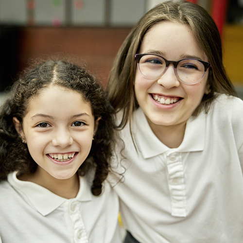 Two girls smiling at school