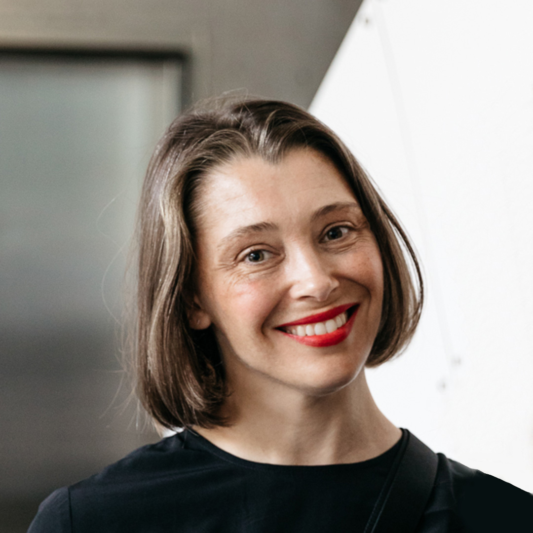 Portrait of Helen Grogan, a Caucasian person with light brown, chin length hair wearing red lipstick and a black t-shirt.jpg