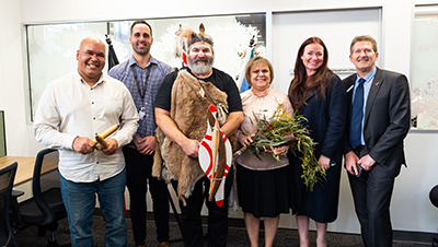 (L-R) Business Project Officer Errol Clarke, Aboriginal Student Engagement Officer Dylan Hunter, Senior Kaurna Man Mickey Kumatpi O’Brien, Manager: Wirringka Student Services Leata Clarke, Division Executive Officer: Health Sciences Emily Adcock and Pro Vice Chancellor: Health Sciences Professor Roger Eston at City East.