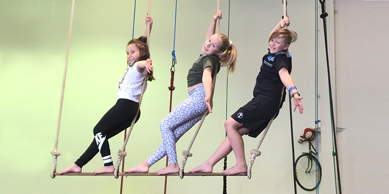 Gracie, 8, Georgina, 10 and Akira, 9 hanging on the trapeze at Cirkidz Circus school, Adelaide. 