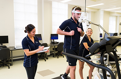 Human Movement, Occupational Therapy and Physiotherapy students Ashleigh Clark, James Fox and Katy Phan in the Exercise Physiology laboratory.=