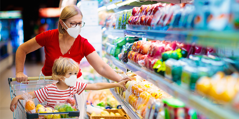 Mother and child shopping in fresh produce section of supermarket