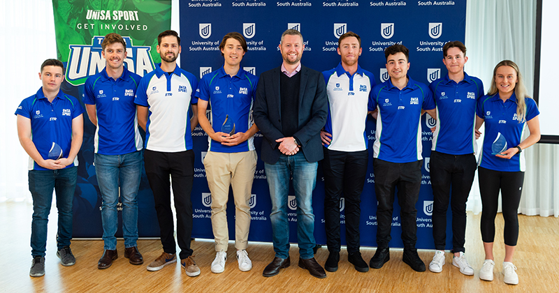 (L-R) Dougy Howard, Cooper Sayers, Ryan Brown, Callum Pearce, Vice Chancellor Professor David Lloyd, Rylan Dowdell, Liam Lawlor, Daniel Siwek and Caitlin Adams.