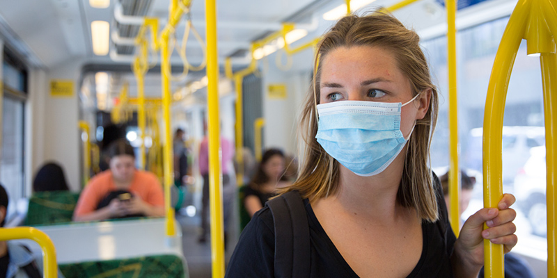 Woman wearing medical face mask on public transport