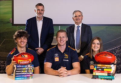 Crows CEO Tim Silvers (left, back) and Executive Dean UniSA Business Professor Andrew Beer (right, back), with high school students Thomas Mansfield (left), Ella Litchfield (right) and Crows player Reilly O’Brien.