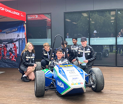 Students from Kingsford Smith School (ACT) with the UniSA Motorsport Club car.